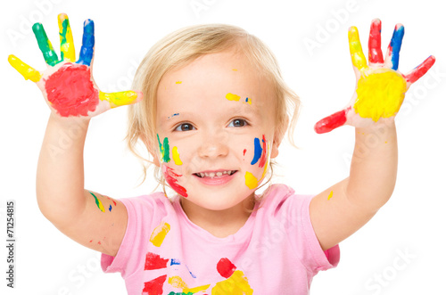 Portrait of a cute little girl playing with paints