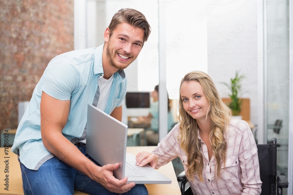 Business people smiling and working together with a laptop Business people smiling and working together with a laptop