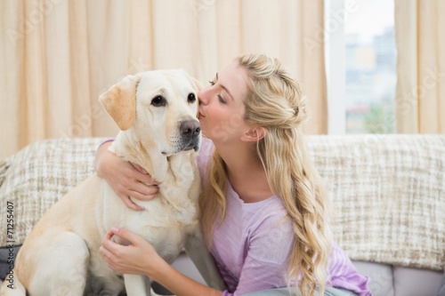 Beautiful blonde relaxing on the couch with pet dog