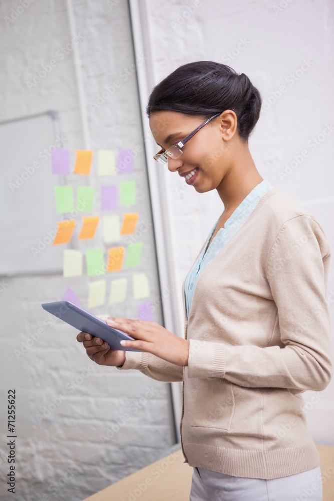 Businesswoman smiling while touching a tablet computer Businesswoman smiling while touching a tablet computer