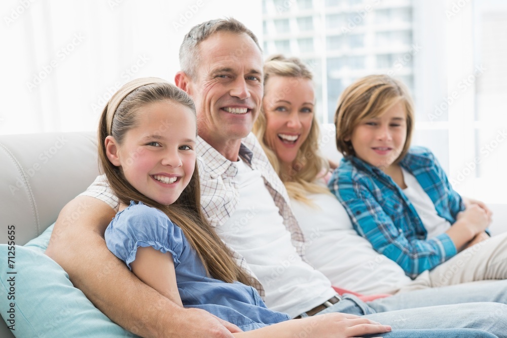 Smiling parents and children sitting together on couch Smiling parents and children sitting together on couch