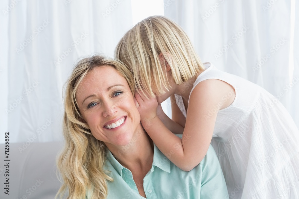 Fototapeta premium Mother sitting with her daughter whispering a secret