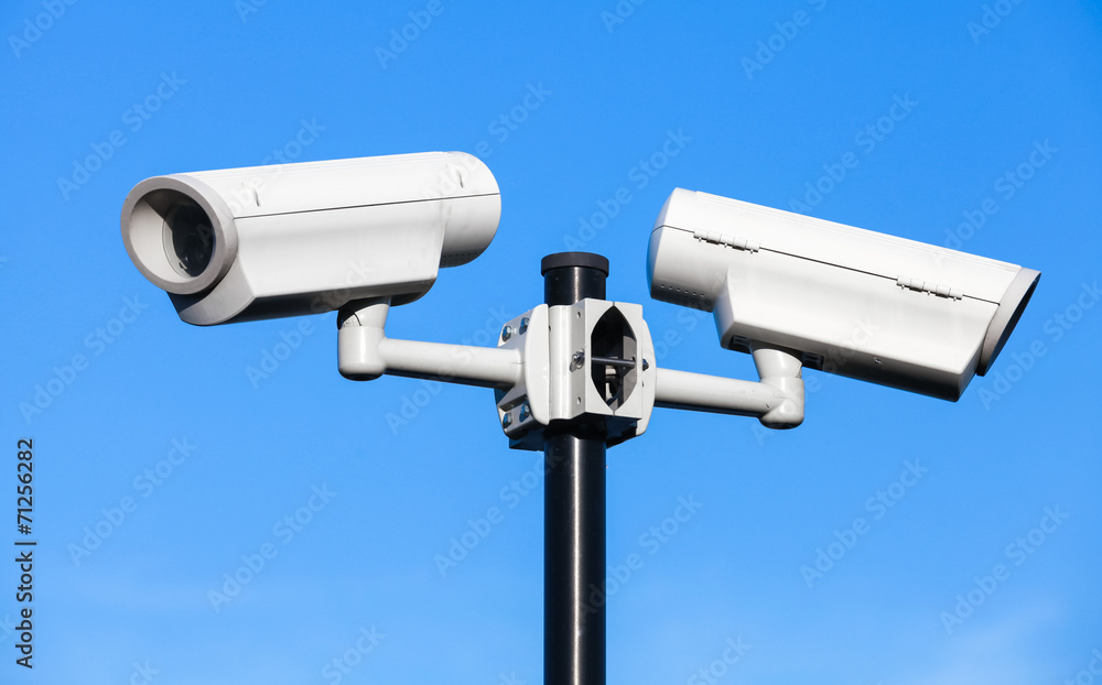 Two closed-circuit television cameras mounted on black pole Two closed-circuit television cameras mounted on black pole