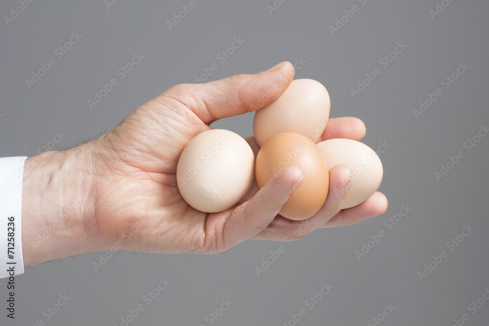 Hand with four hens eggs.