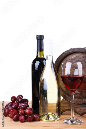 Wine in goblet and in bottles, grapes and barrel