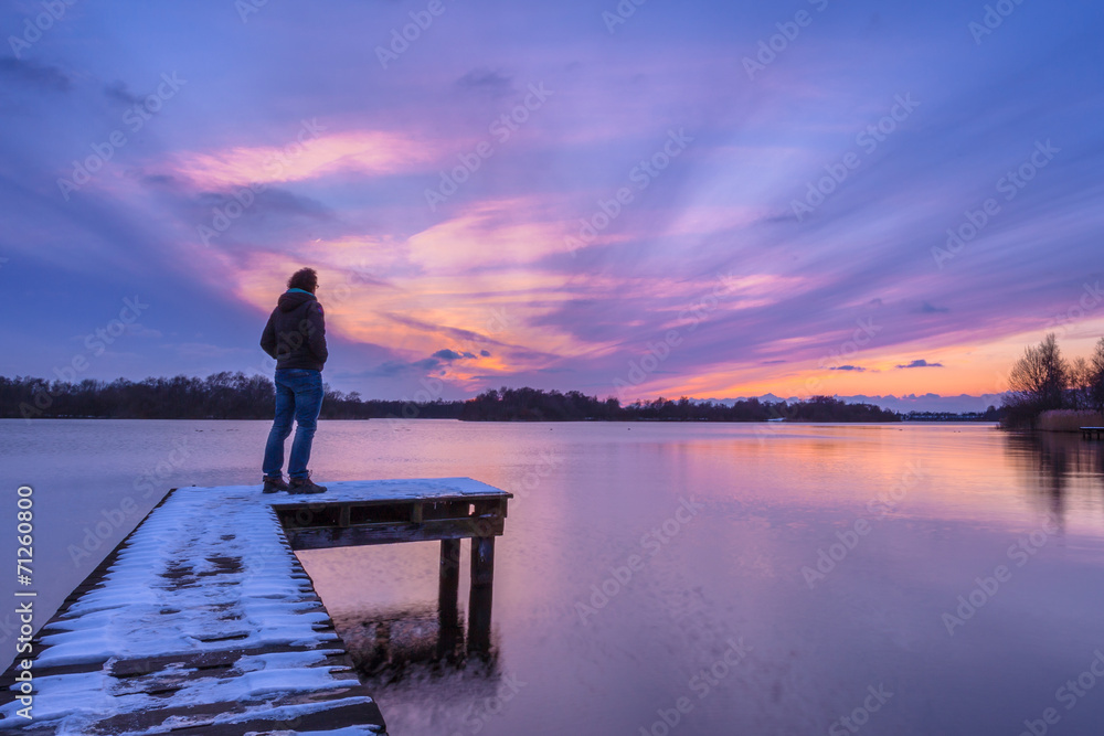 Fototapeta premium Man Looking at the Sunset From a Pier