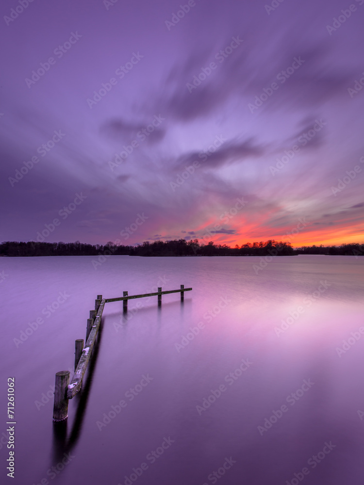 Purple Sunset over Tranquil Lake with Wooden Mooring Post