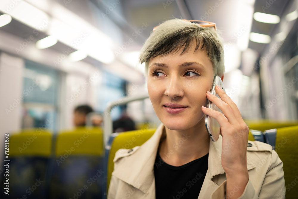 Happy young woman talking at the phone inside metro subway. Pari Happy young woman talking at the phone inside metro subway. Pari