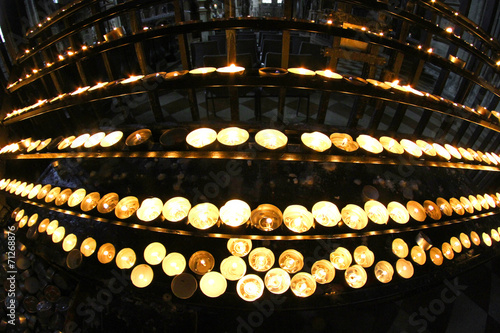 candelabrum in church with many wax candles and flickering flame