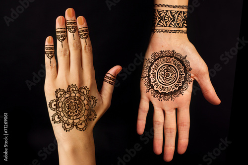 hand with mehendi on black background