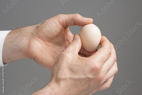 Male;s hends with hen's egg. photo