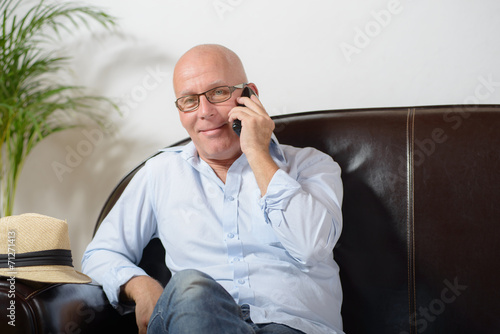 Canvas Print a senior sitting in a sofa and phone