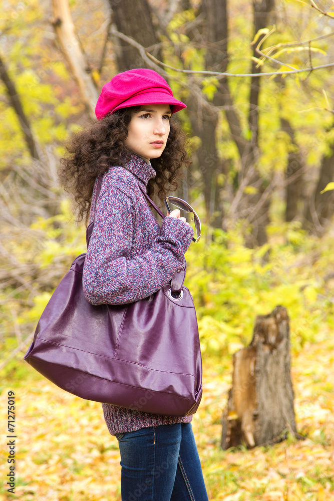 Young stylish woman with a big bag in the autumn park Young stylish woman with a big bag in the autumn park