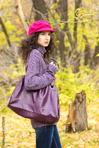 Young stylish woman with a big bag in the autumn park