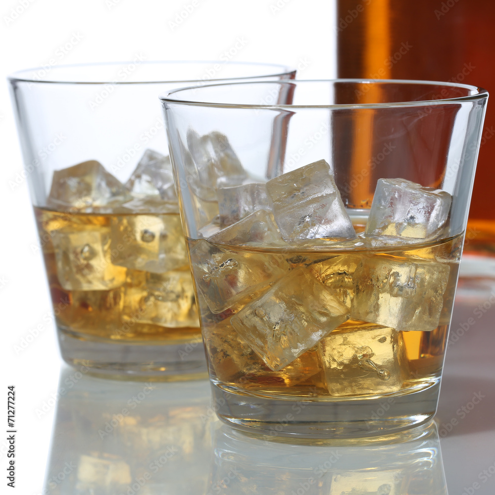 Whisky oder Whiskey im Glas und Flasche mit Eiswürfel Whisky oder Whiskey im Glas und Flasche mit Eiswürfel