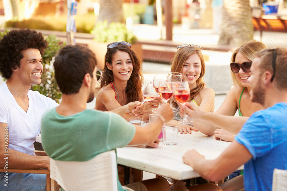 Group Of Young Friends Enjoying Meal In Outdoor Restaurant Group Of Young Friends Enjoying Meal In Outdoor Restaurant