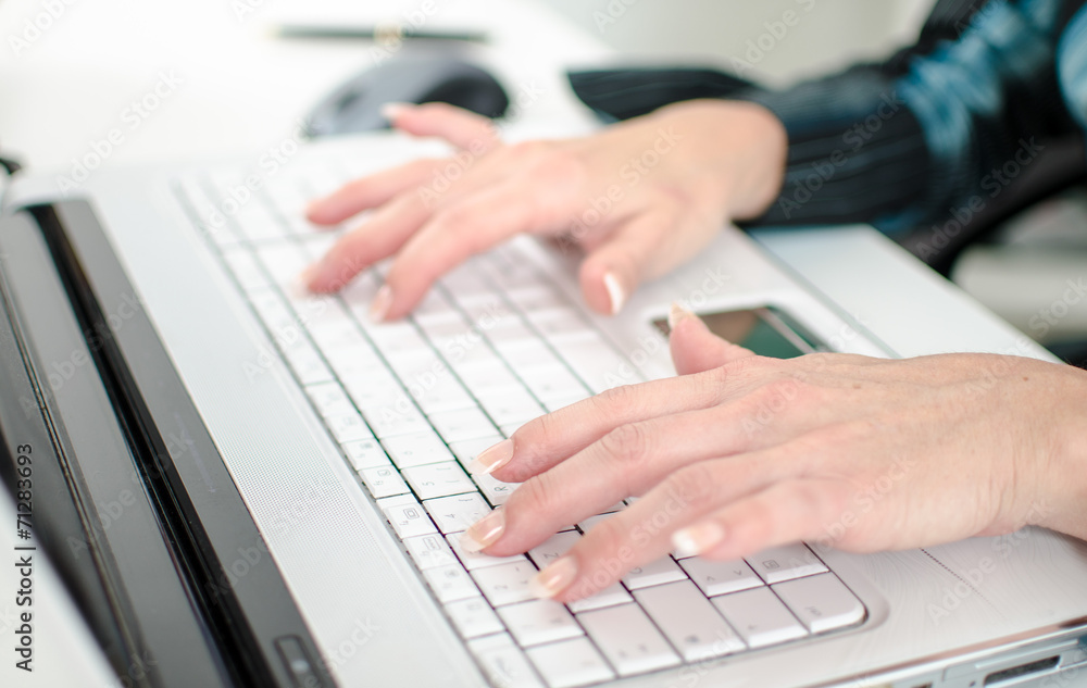 Female hands typing on a laptop computer keyboard Female hands typing on a laptop computer keyboard
