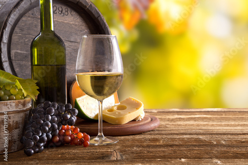 Fototapeta Naklejka Na Ścianę i Meble -  Wine still-life, glass, young vine and bunch of grapes