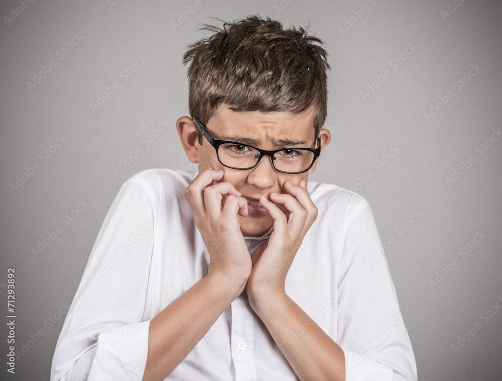 Headshot anxious stressed boy isolated on grey background Headshot anxious stressed boy isolated on grey background