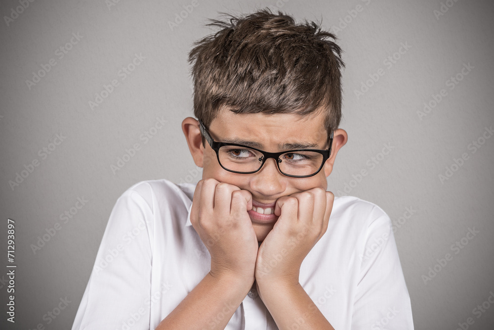 Headshot anxious stressed boy isolated on grey background Headshot anxious stressed boy isolated on grey background