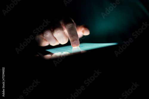 Man using a tablet in the dark