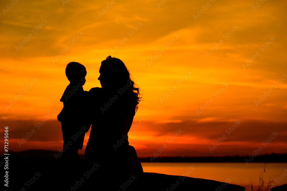 Silhouette of a young mother with her little child