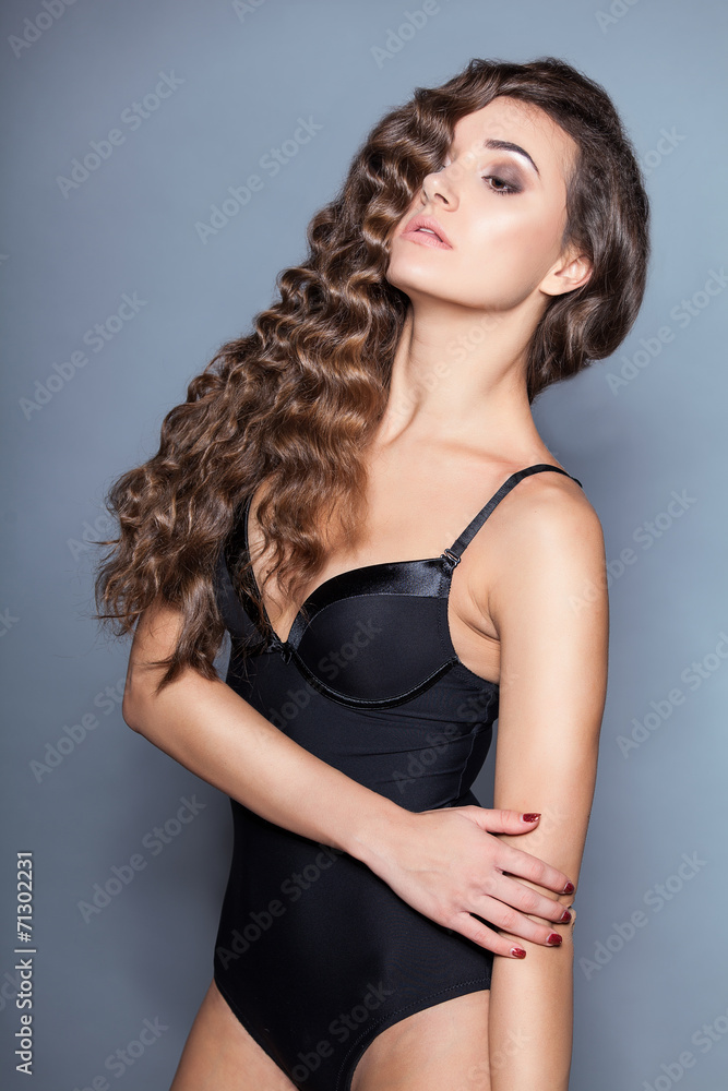 Fototapeta premium Portrait of a young brunette woman with beautiful hair