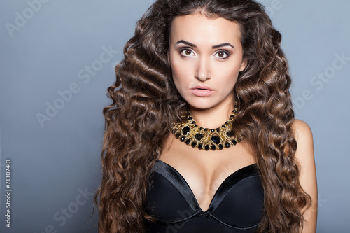 Fashion model with long curly hair. Fashion model in studio