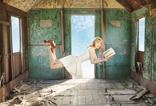 Fényképezés Glad levitating redhead with the book