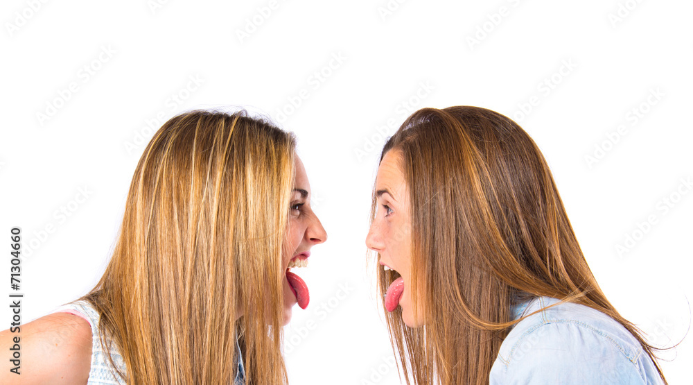 Girls doing a joke over isolated white background Girls doing a joke over isolated white background