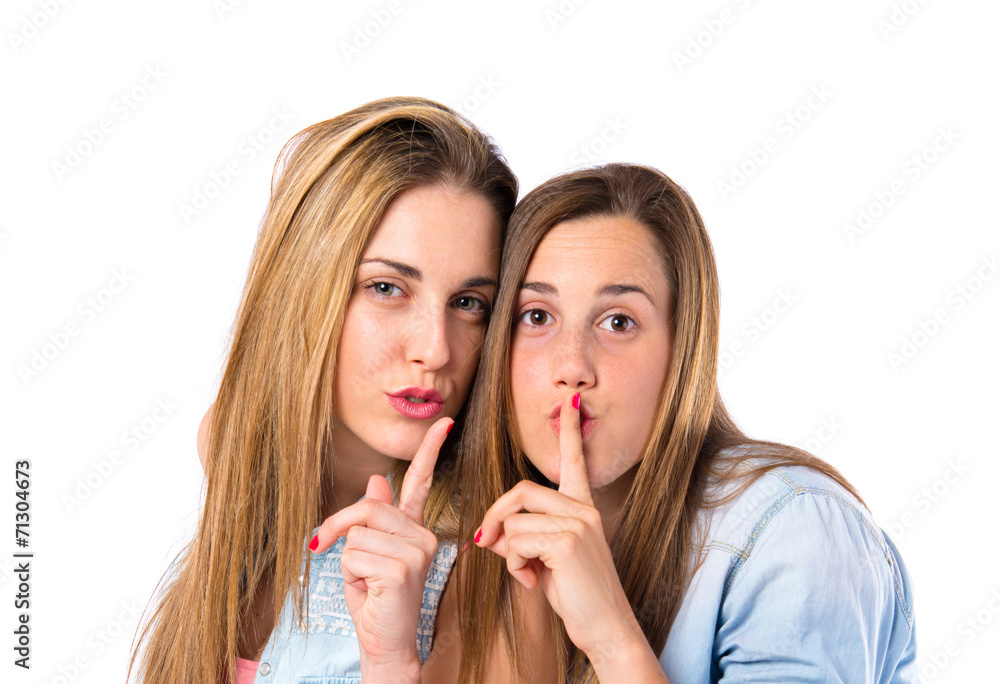 Friends making silence gesture over isolated white background Friends making silence gesture over isolated white background