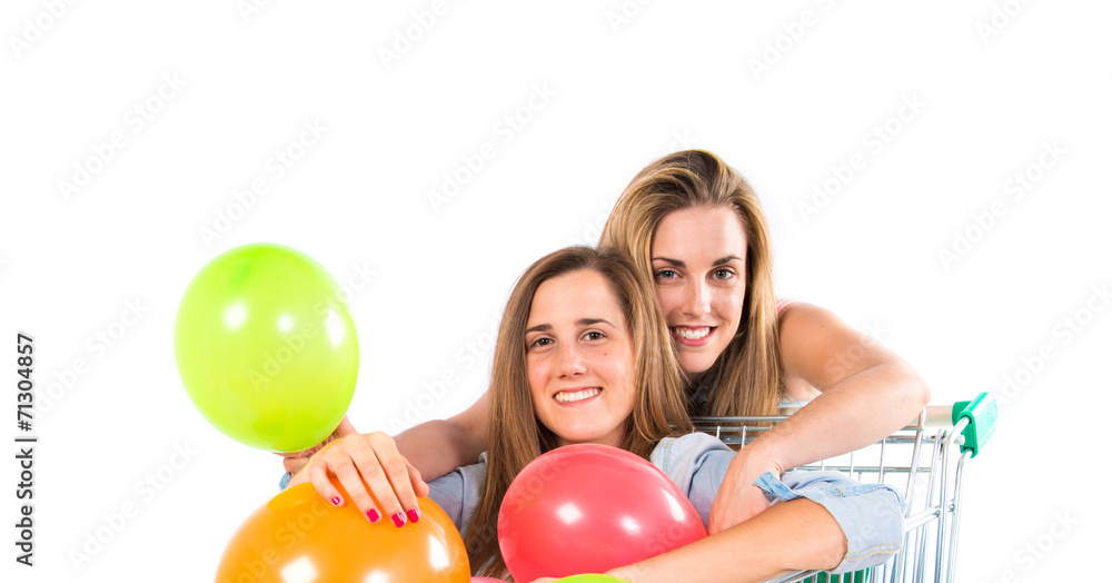 Girl with many balloons inside supermarket cart over white backg Girl with many balloons inside supermarket cart over white backg