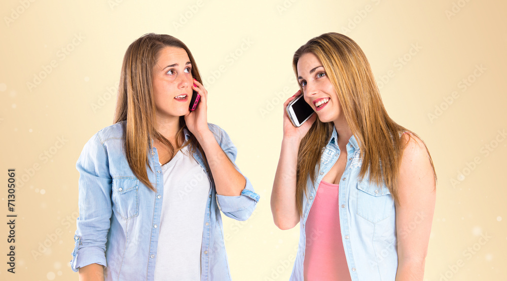 Young girls talking to mobile over gloss background Young girls talking to mobile over gloss background