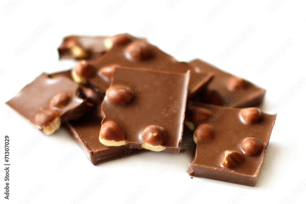 Chocolate pieces with nuts on white background close-up Chocolate pieces with nuts on white background close-up