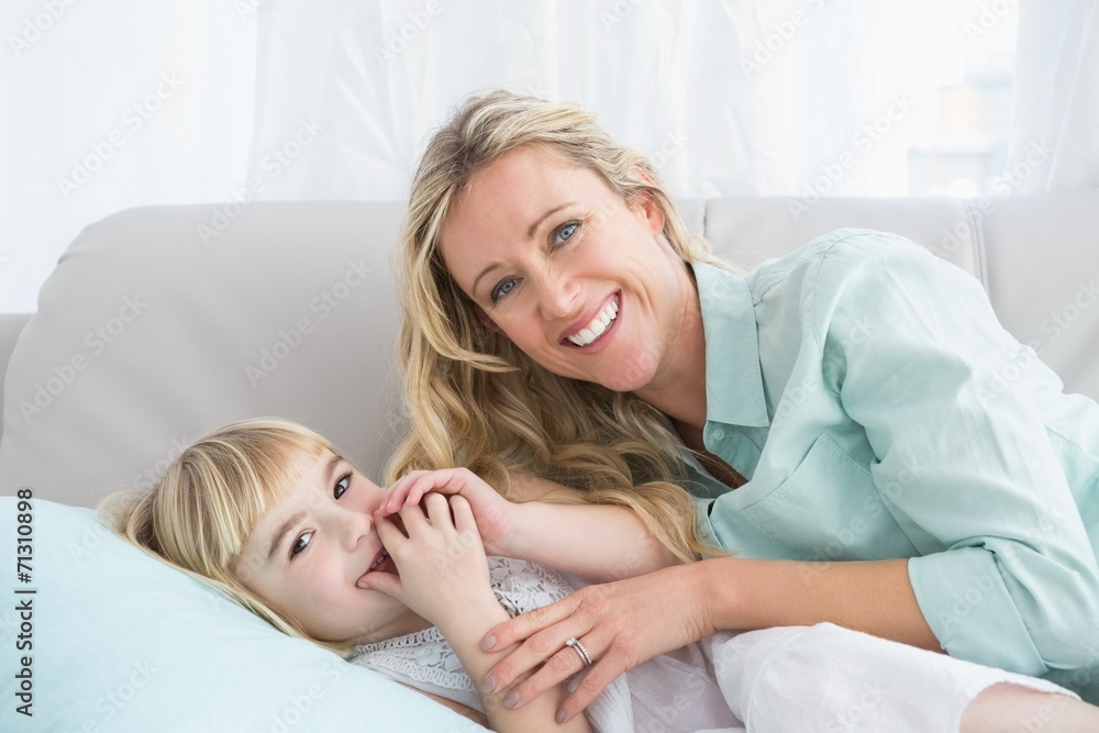 Beautiful mother and daughter lying on the couch Beautiful mother and daughter lying on the couch