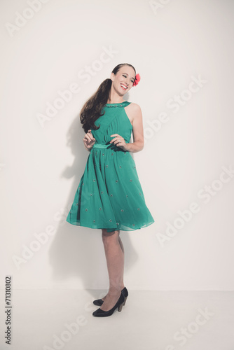 Retro fifties brunette fashion woman wearing red flower and gree