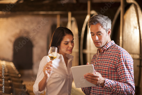 Couple tasting a glass of white wine in a traditional cellar sur