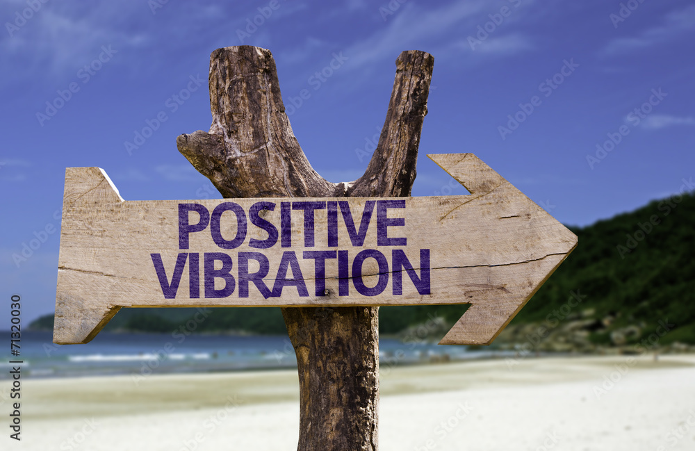 Positive Vibration wooden sign with a beach on background