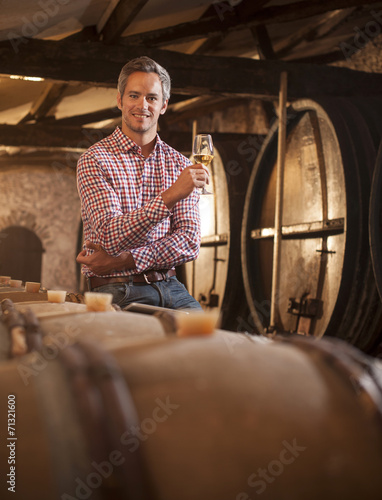 Bilde på lerret Professional winemaker tasting a glass of white wine in his trad