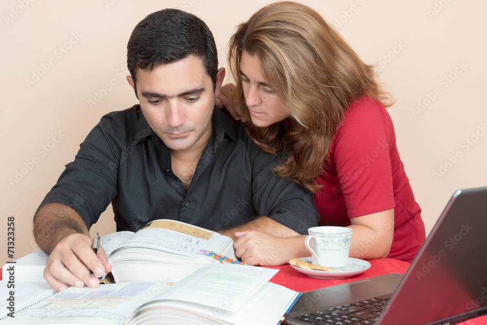 Hispanic man and woman studying at home Hispanic man and woman studying at home