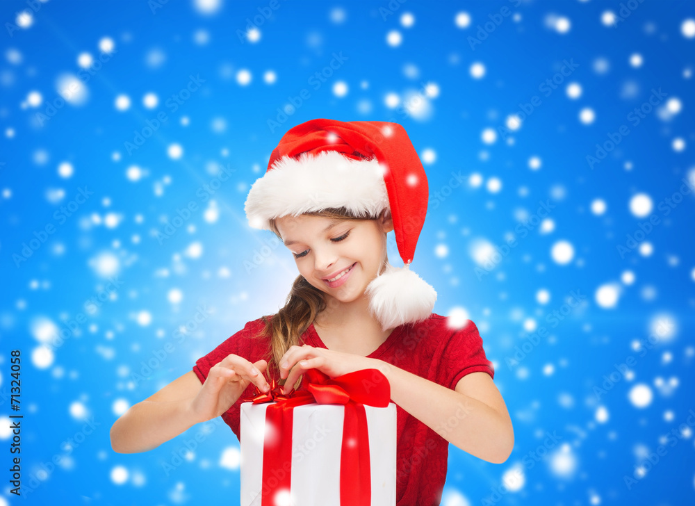 smiling girl in santa helper hat with gift box smiling girl in santa helper hat with gift box