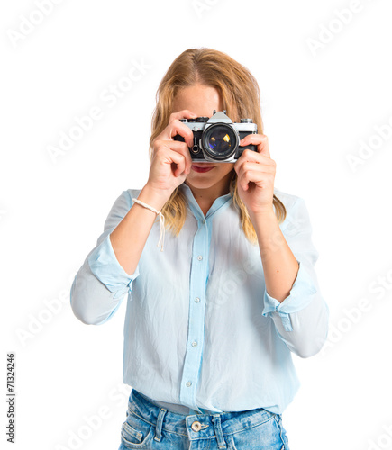 Blonde woman photographing over white background