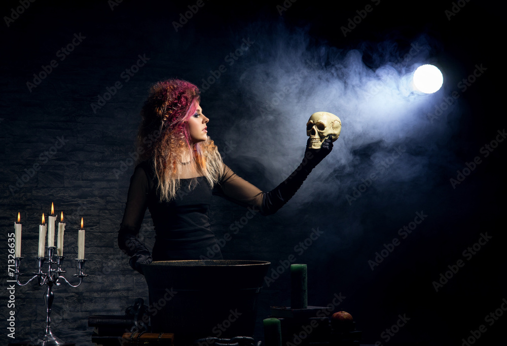 Witch making witchcraft on a smoky Halloween background