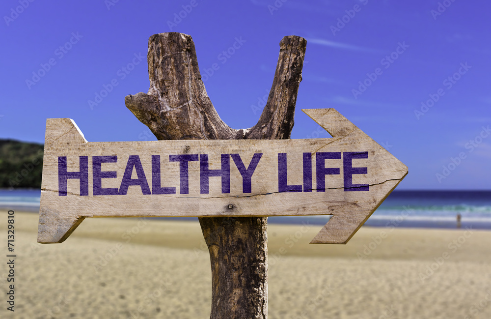 Healthy Life wooden sign with a beach on background