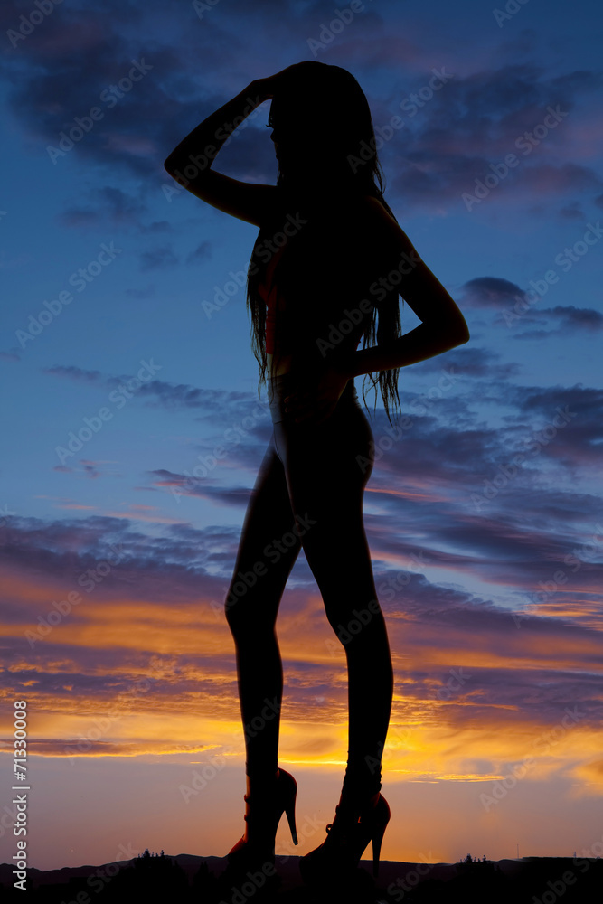 Silhouette woman stand high heels hands on head and hip