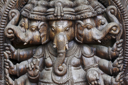 A close up of a carved wodden Ganesha with many details