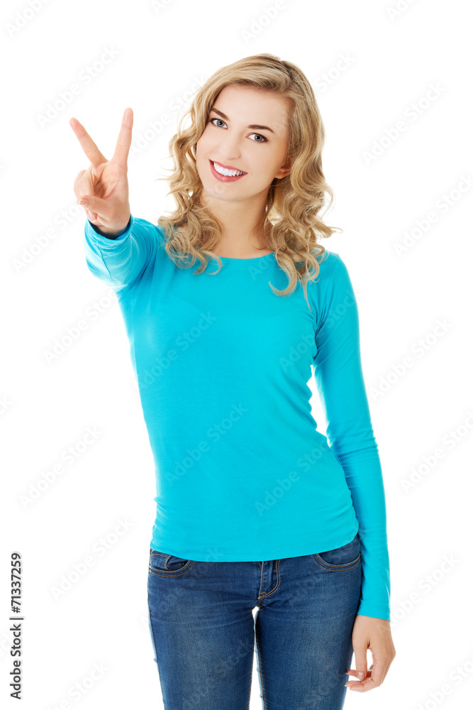 Young woman showing victory sign Young woman showing victory sign