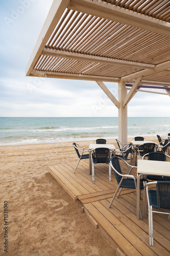 Sea side bar interior with wooden floor and metal armchair
