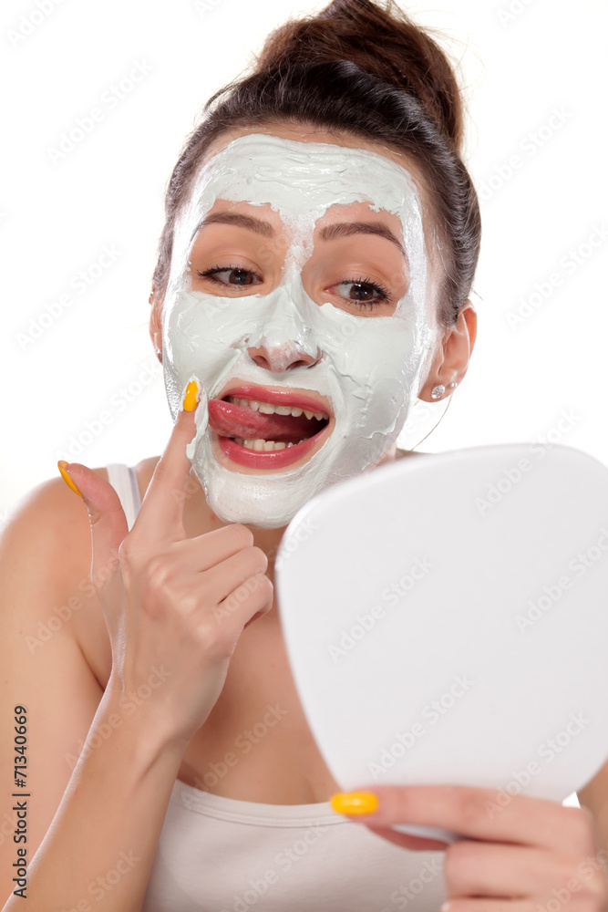 young woman testing a face mask with her tongue