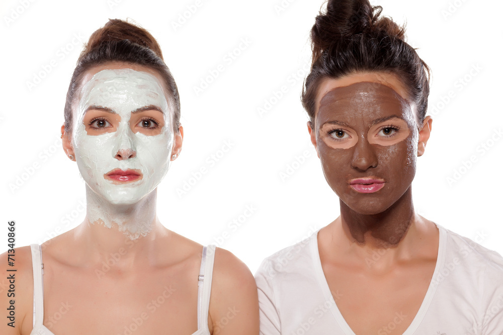 two serious young women with masks posing on white two serious young women with masks posing on white